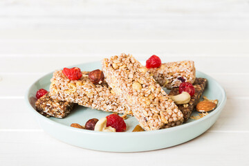 Various granola bars on table background. Cereal granola bars. Superfood breakfast bars with oats, nuts and berries, close up. Superfood concept