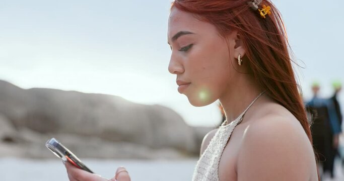 Happy, woman and typing with phone at beach for social media, reading notification and update travel blog for holiday, vacation and summer. Gen z girl scroll on smartphone at ocean for mobile contact