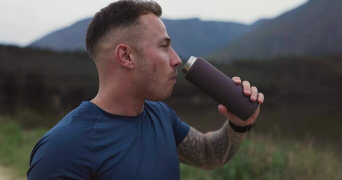 Man, fitness and drinking water in nature for sports break, energy and workout performance in environment. Thirsty runner with bottle for hydration, nutrition or healthy recovery for outdoor exercise