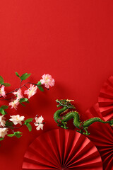 Happy Chinese New Year 2024 vertical banner template. Folding paper fans, dragon, sakura on red...