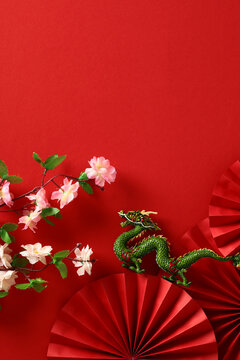 Happy Chinese New Year 2024 vertical banner template. Folding paper fans, dragon, sakura on red background