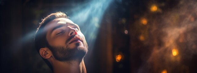 Man Engaged in Reiki Energy Healing Practice. A man in moment of tranquility during Reiki session, with sunlight illuminating his face, symbolizing the flow of healing energy. - obrazy, fototapety, plakaty