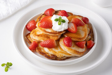 Mini pancakes with strawberry and sour cream