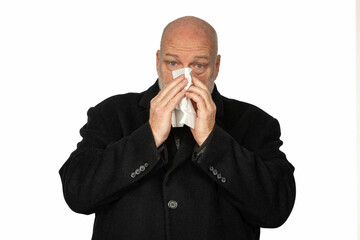 Man in Coat Sneezing into Tissue: Allergy and Health Concept, On White Background