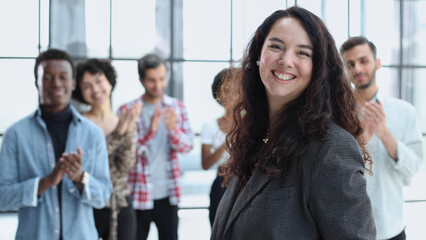 Obraz premium business woman with her staff in background at office