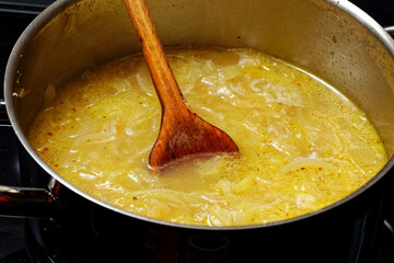 Preparing onion soup in cooking pot
