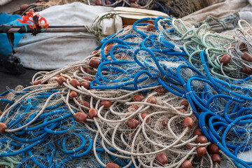 A set of fishing nets piled up on a fishing boat after a fishing trip. Nets joined by colored ropes...