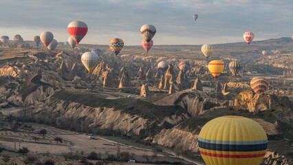 plenty of hot-air balloons flying over the fairy chimneys, Göreme, Cappadocia, Turkey - obrazy, fototapety, plakaty