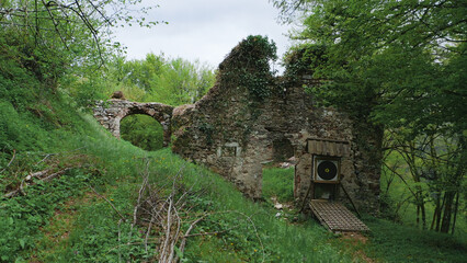 Amidst the overgrown ruins of an abandoned kiln, a solitary stone wall stands tall, its target...