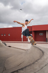 young man skater jumps from the ramp of a skate park. vertical composition © magui RF
