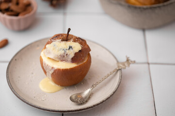 Baked apples stuffed with almonds, marzipan, raisins in vanilla syrup on plate on a Christmas background. Traditional german Christmas dessert Bratapfel.