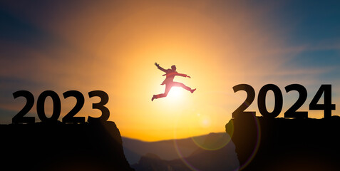 New Year 2024 concept.Businessman jumping on cliff 2024 over the precipice at amazing...