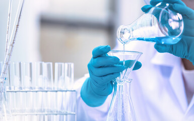 Fototapeta premium Doctor or scientist using pipette to drop a sample to test tube in medical research lab or science laboratory