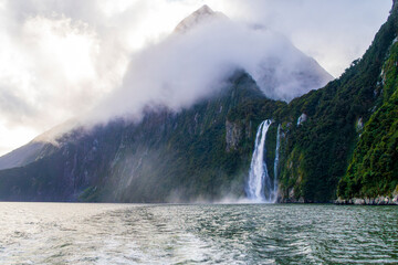 Photograph of Waterfalls from a boat on a misty and rainy day in Milford Sound in Fiordland National Park on the South Island of New Zealand