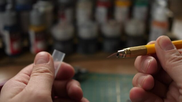 showing sharp modeling hobby knife, painting minis, miniatures for rpg game, cleaning moldlines