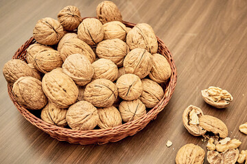 Appetizing and nutritious Walnuts on a brown table in a wicker basket.