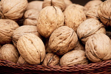 Appetizing and nutritious Walnuts on a brown table in a wicker basket.