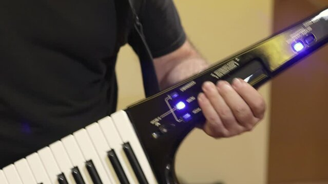 crop of man playing keytar in studio