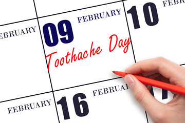 February 9. Hand writing text Toothache Day on calendar date. Save the date. - Powered by Adobe
