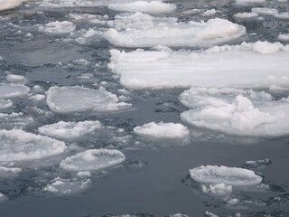 unusual and delicate ice with thawed areas and cascades on the winter river