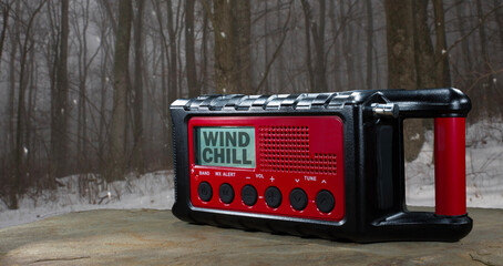 Winter scene behind a weather radio with wind chill watch