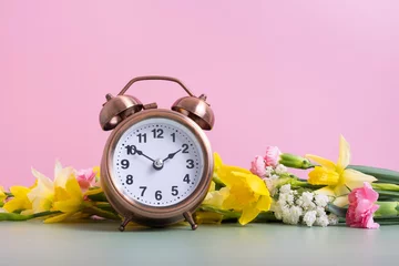 Deurstickers Alarm clock with spring flowers. Spring time, daylight savings concept, spring forward © Alina