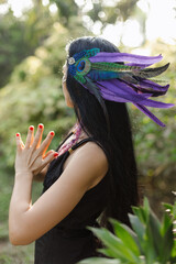 Close-up of headdress made of purple long feathers stylized as North American Indians on woman. 