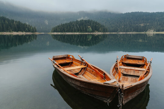 Two Rowboats on Morning Mountain Lake with Mist