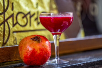Photo elegant pomegranate juice glass with a pomegranate on the side