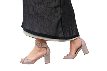 Well groomed ladies feet in high heeled sandals. Close up of lower legs and feet. The woman wears a long skirt made of two layers. Isolated in front of a transparent background.