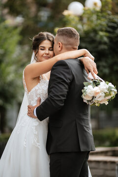 the groom in a brown suit and the bride in a white dress