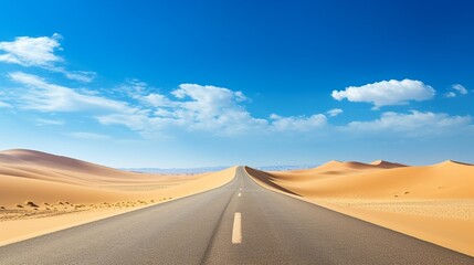 Fototapeta na wymiar A desert highway stretching into the horizon, surrounded by golden sand dunes and a clear blue sky.