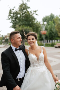 the groom in a brown suit and the bride in a white dress