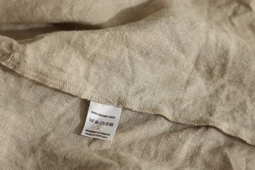 Clothing label on beige garment, closeup view