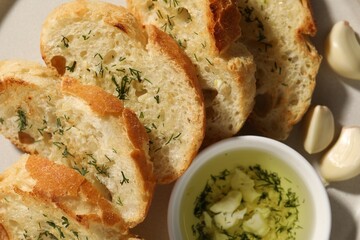 Tasty baguette with garlic and dill on table, closeup