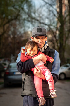 Dad embraces his young daughter in a hug.