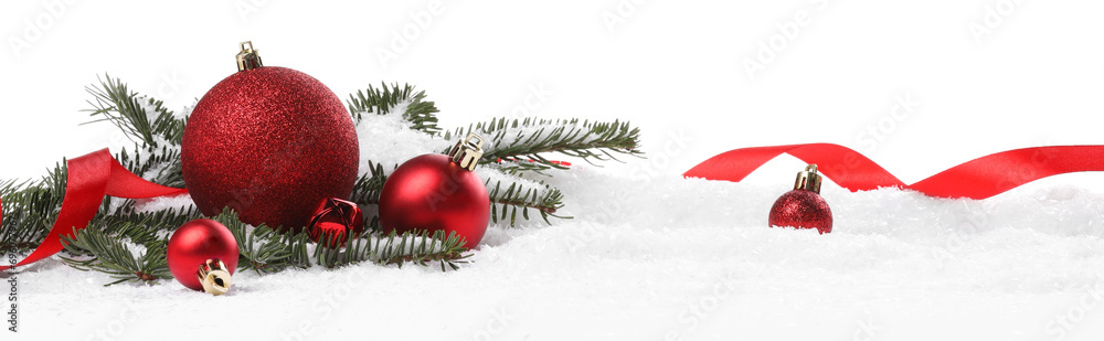 Wall mural Beautiful red Christmas balls, fir tree branch and ribbon on snow against white background