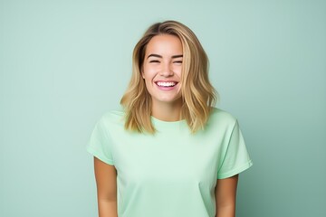 Obraz premium Laughing Woman in Light Green T-shirt on Pastel Mint Background. Generative AI.