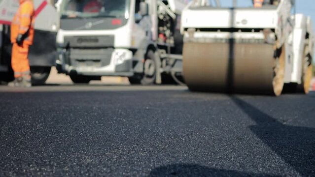 A layer of freshly laid asphalt. Road surface repair. Construction of a new road. Rollers level