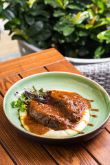 Traditional German braised pork cheeks in brown red wine sauce