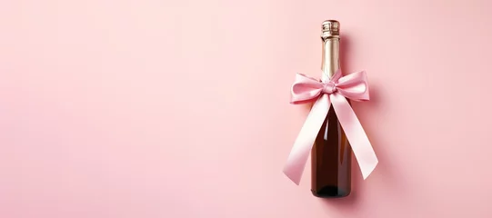 Fotobehang Generative AI, Pink champagne bottle mockup with bow on pink background © DELstudio