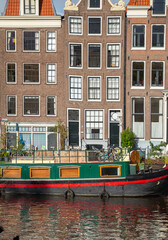 Fototapeta na wymiar houseboat and townhouse on the canal, Amsterdam
