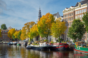 Amsterdam canal and houseboat/ townhouse with autumn colorful trees, Amsterdam