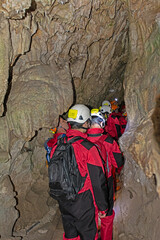 Men in cave suits explore a cave.