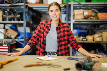 Portrait of an positive female worker in large store warehouse