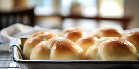 Close up of fresh baked dinner roll buns on a kitchen table, blurry window background	