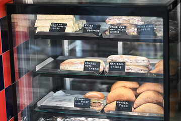 Assortment of sandwiches with lettuce, salmon, ham for sale on counter of market, cafe, store, shop...