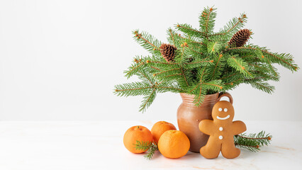Natural christmas tree branches with cones in retro clay jug vase, baked gingerbread man and fresh...