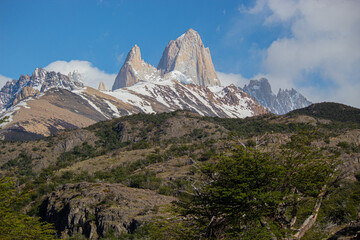 Landscape of snow-capped mountains and forest with a cloudy sky. Cerro Fitz Roy, Chaltén, Argentina. 