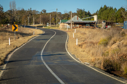 A road leading past a small sawmill on a farm in a rural area near Stanthorpe in Queensland country, Australia.